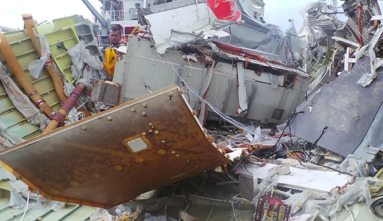 Seorang petugas memperhatikan kondisi bagian belakang pesawat AirAsia QZ8501 saat berhasil diangkat ke atas kapal Crest Onyx,  Kalteng, Sabtu (10/1/2015). (Liputan6.com/Rochmanuddin)