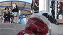 Seekor penguin Afrika melakukan parade untuk menyambut Natal di taman rekreasi Hakkeijima Sea Paradise, Tokyo, 5 Desember 2017. Penguin Santa tersebut berjalan di sekitar taman dengan mengenakan jubah layaknya Santa Claus. (Toru YAMANAKA/AFP)