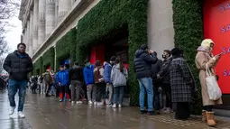 Antrean pembeli, yang beberapa mengenakan masker, untuk memasuki department store Selfridges menjelang penjualan Boxing Day di pusat kota London, Minggu (26/12/2021).  'Boxing Day' adalah hari saat toko-toko di Inggris menggelar diskon besar-besaran, sehari setelah Natal. (Niklas HALLE'N / AFP)
