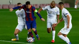 Penyerang Barcelona, Lionel Messi menguasai bola saat pemain Ferencvaros berusaha menghentikannya pada laga pertama Grup G Liga Champions 2020-2021 di Camp Nou, Rabu (21/10/2020) dini hari WIB. Main dengan 10 pemain, Barcelona mampu mencukur Ferencvaros 5-1. (AP Photo/Joan Monfort)