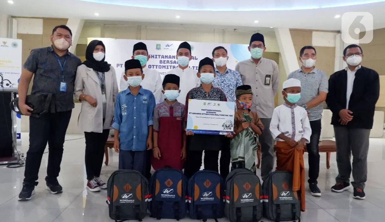 Anak-anak penerima manfaat foto bersama dengan Pimpinan BAZNAS Rizaludin Kurniawan, Branch Head WOM Finance Cab. Mauk Djoko Purnomo, Ketua BAZNAS Kota Tangerang H.M. Aslie Elhusyaery dan jajaran pengurus Rumah Sehat BAZNAS di Gedung MUI Kota Tangerang, Minggu (10/10/2021). (Liputan6.com/HO/Rizki)