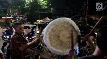 Warga menabuh beduk saat memeriahkan malam takbiran di sepanjang Jalan Mas Mansyur, Tanah Abang, Jakarta Pusat, Kamis (14/6) malam. Pemerintah menetapkan 1 Syawal 1439 Hijriah atau Idul Fitri jatuh pada Jumat (15/6) besok. (Liputan6.com/Johan Tallo)