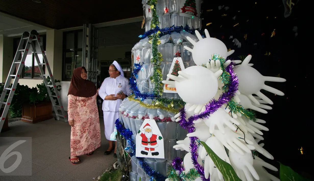 Seorang suster saat menjelaskan kepada pengunjung tentang pohon Natal dari limbah medis di RS Panti Nugroho, Sleman, Rabu (23/12). Ratusan infus, sarung tangan dan masker bekas pakai yang telah disterilkan dirangkai menjadi pohon Natal. (Boy Harjanto)