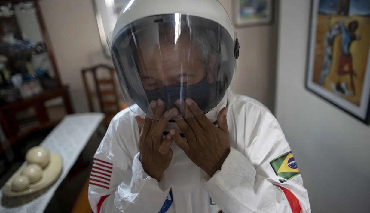 Akuntan Brasil Tercio Galdino (66) mengenakan helm saat akan pergi ke Pantai Copacabana dengan pakaian pelindung mirip astronaut di Rio de Janeiro, Brasil, 12 Juli 2020. Pakaian tersebut juga dipakai untuk bersenang-senang karena minatnya yang besar dalam astronomi. (Mauro Pimentel/AFP)