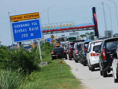 Kendaraan antre menuju pintu keluar Tol Brebes Barat, Jawa Tengah, Sabtu (23/12). Untuk mengurangi kemacetan di pintu Tol Brebes Timur petugas mengalihkan arus lalu lintas keluar Tol Brebes Barat. (Liputan6.com/Helmi Fithriansyah)