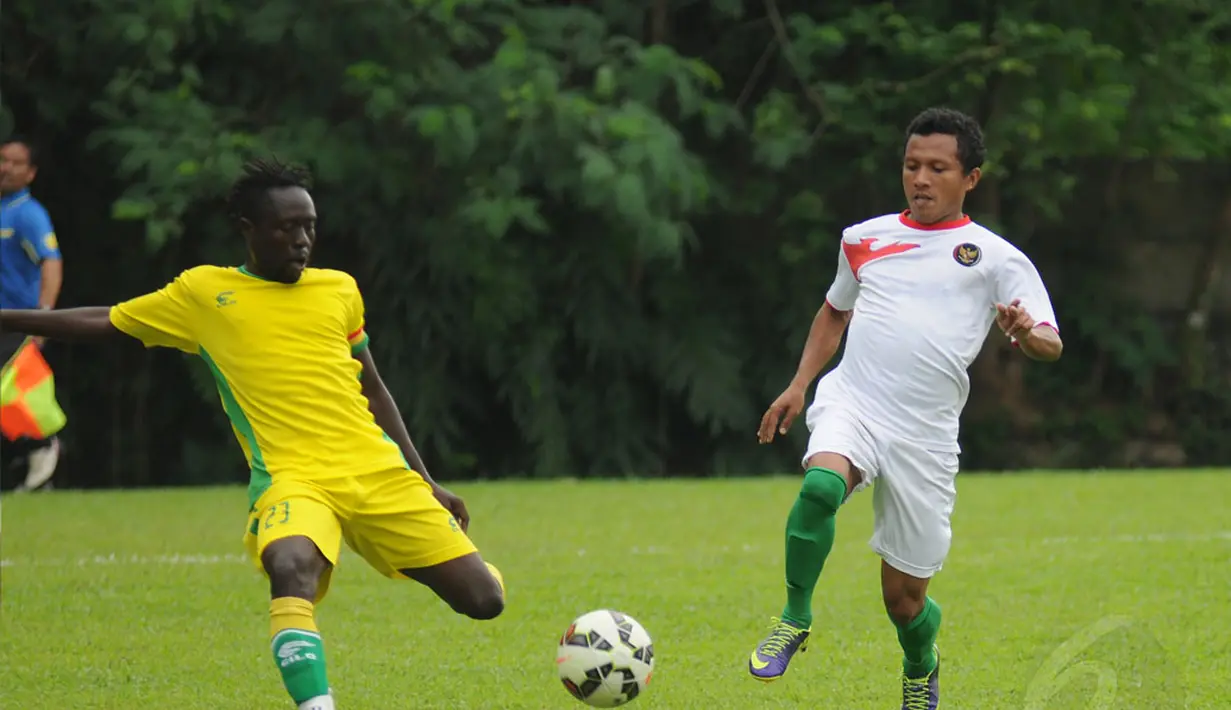 Gelandang Timnas U-23 Indonesia, Hendra Bayauw (kanan) berebut bola dengan salah satu pemain asing saat berlatih tanding di POR Sawangan, Depok, Rabu (31/12/2014). (Liputan6.com/Helmi Fithriansyah)