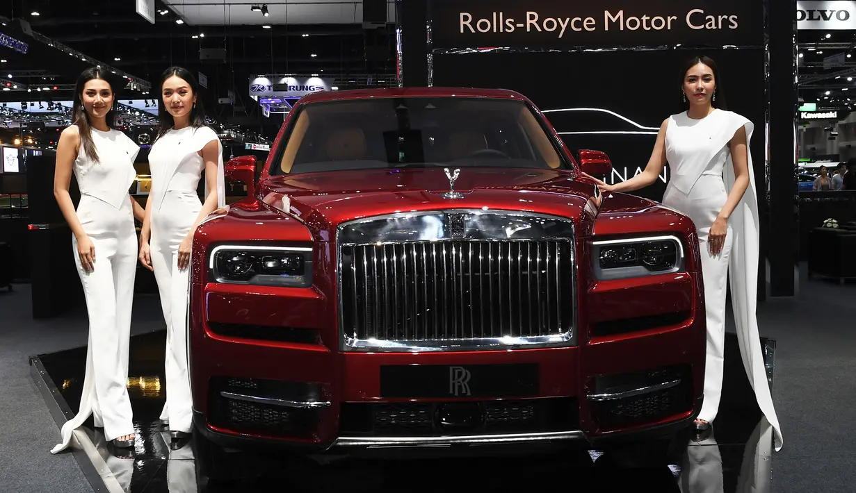 Tiga Model berpose di samping Rolls Royce Cullinan 2019 selama Thailand International Motor Expo di Bangkok (29/11).  Thailand International Motor Expo dimulai pada 29 November dan berakhir pada 10 Desember 2018. (AFP Photo/Lillian Suwanrumpha)