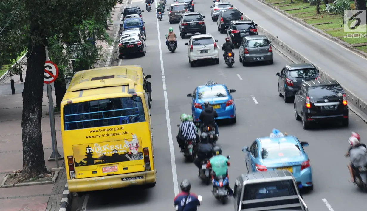 Pengendara motor melintas di sisi mobil parkir di jalur khusus motor di sekitar Jalan Medan Merdeka Barat, Jakarta, Kamis (1/3). Jalur yang seharusnya digunakan untuk pengendara motor tersebut hingga kini belum steril. (Liputan6.com/Helmi Fithriansyah)