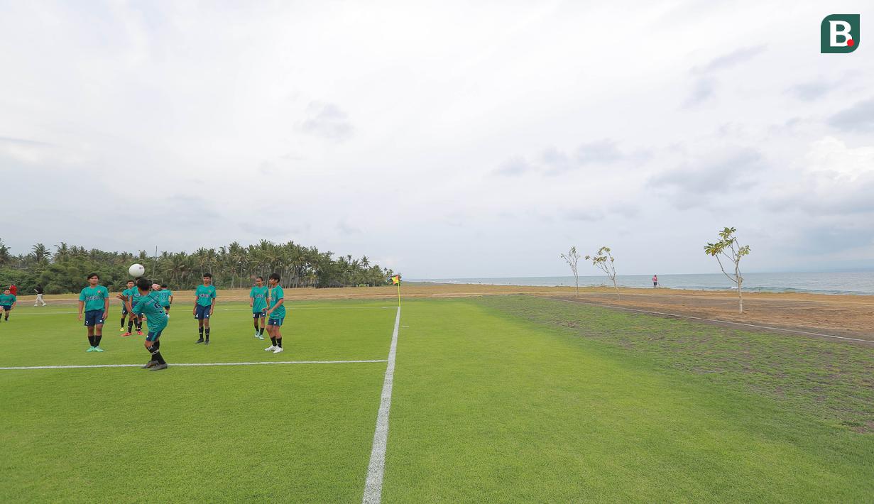 Sejumlah pesepak bola cilik bermain bola di Training Ground Bali United, Gianyar, Senin (28.03/2022). Mereka tampak senang menjajal lapangan latihan Bali United yang berada di pinggir pantai. (Bola.com/ M Iqbal Ichsan)