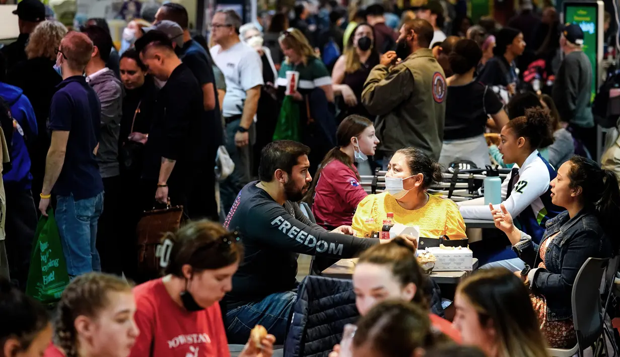 <p>Pelanggan, beberapa mengenakan masker, makan malam di Reading Terminal Market di Philadelphia, Jumat (22/4/2022). Kota itu meninggalkan mandat masker dalam ruangan pada hari Jumat, hanya beberapa hari setelah menjadi kota metropolitan AS pertama yang menerapkan kembali wajib masker sebagai tanggapan atas peningkatan kasus COVID-19 dan rawat inap. (AP Photo/Matt Rourke)</p>