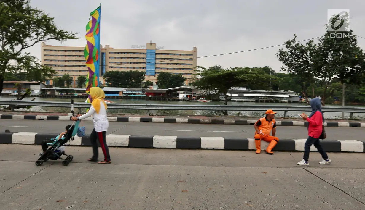 Seorang ibu sedang mendorong kereta bayi saat Car Free Day di Danau Sunter, Jakarta Utara, Minggu (28/1). (Liputan6.com/Fery Pradolo)