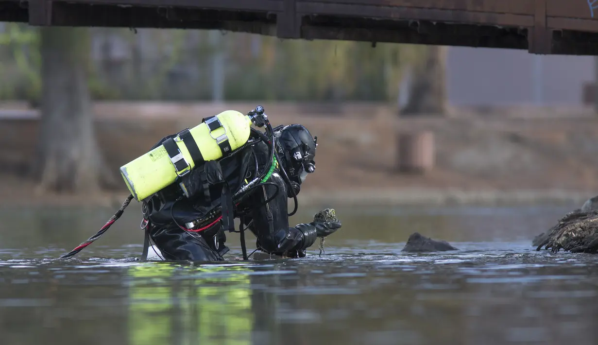 Petugas mencari bukti pembantaian di San Bernardino yang mungkin telah dilemparkan ke Seccombe Lake, Jumat (11/12/2015). Warga AS, Syed Farook, 28,  istrinya menyerbu Inland Regional Centre dan menewaskan 14 orang. (AFP Photo /Guillaume Meyer)