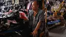Seorang pedagang menggunakan selembar kertas untuk mendinginkan dirinya saat menunggu pelanggan di Jakarta pada 7 Mei 2024. (ADEK BERRY / AFP)