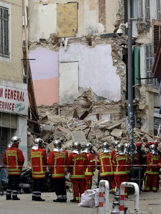 Petugas pemadam kebakaran terlihat berada dekat bangunan yang runtuh di kota Marseille, selatan Prancis, Senin (5/11). Kuat dugaan insiden runtuhnya bangunan tersebut karena sudah tua dan dalam kondisi rusak. (AP/Claude Paris)