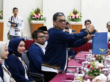 Ketua Umum Partai Garuda Ahmad Ridha Sabana menyerahkan dokumen daftar bakal calon legislatif (bacaleg) kepada Ketua Komisi Pemilihan Umum (KPU) Hasyim Asy'ari di Gedung KPU, Jakarta, Kamis (11/5/2023). Partai Garuda mendaftarkan 580 bacaleg untuk DPR pada Pemilu 2024. (Liputan6.com/Herman Zakharia)
