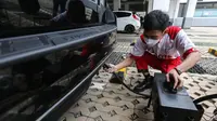 Petugas melakukan uji emisi bersama Garda Oto milik pelanggan pada rangkaian acara Estafet Peduli Bumi di kawasan perkantoran Asuransi Astra, Jakarta (11/12/2022). (Liputan6.com)