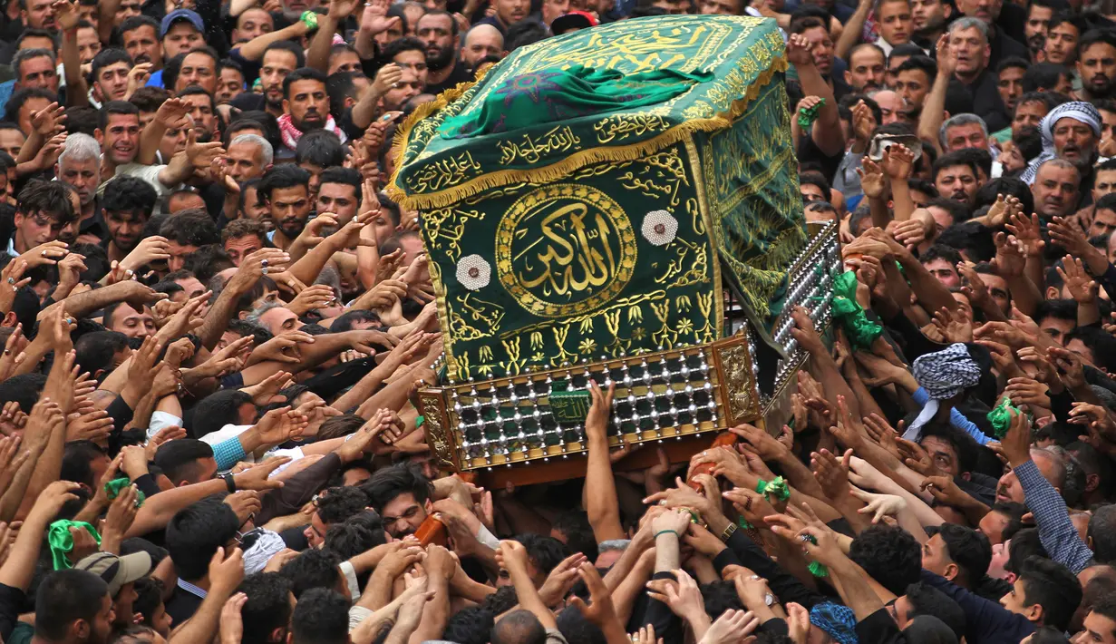 Umat Syiah Irak membawa peti jenazah saat memperingati wafatnya Imam Musa al-Kadhim di Kadhimiya, Irak (12/4). Ribuan peziarah mendatangi tempat tersebut untuk memperingati wafatnya Musa al-Kadhim. (AFP Photo/Ahmad Al-Rubaye)