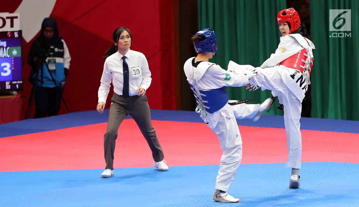 Atlet taekwondo putri Indonesia, Fitriyana Yusuf berhadapan dengan Liu Qing dari Makau pada babak 16 besar di Jakarta Convention Center (JCC), Senin (20/8). Fitriyana kalah tipis 21 - 25 pada kelas Wanita 67 kg. (Liputan6.com/Fery Pradolo)