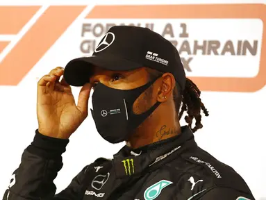 Pembalap Mercedes Lewis Hamilton memberi isyarat usai meraih pole position pada sesi kualifikasi di Formula 1 Sirkuit Internasional Bahrain di Sakhir, Bahrain, Sabtu (28/11/2020). Lewis Hamilton dinyatakan positif COVID-19. (Hamad Mohammed, Pool via AP, File)