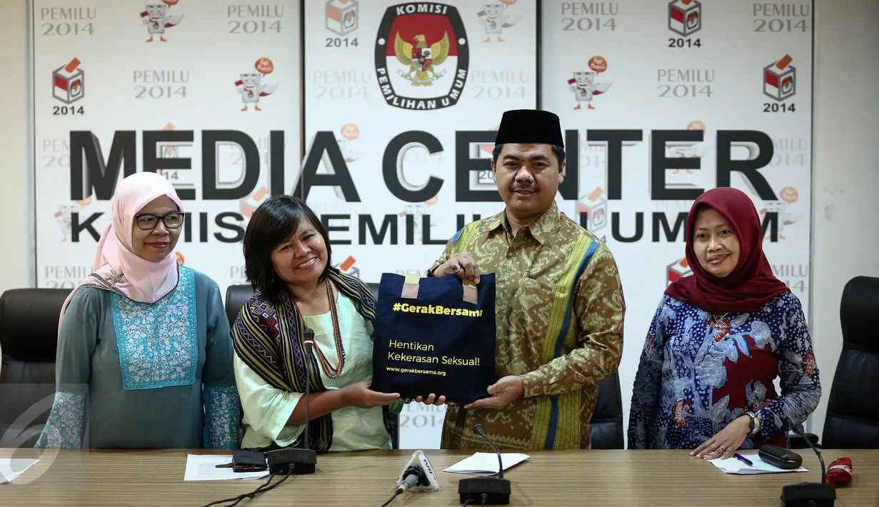 Yuniyanti Chuzaifah, Wakil Ketua Komnas Perempuan, memberikan buku terkait kekerasan terhadap perempuan dan kampanye stop kekerasan terhadap perempuan kepada Ketua KPU Juri Ardiantoro di Jakarta, Jumat (10/2). (Liputan6.com/Faizal Fanani)