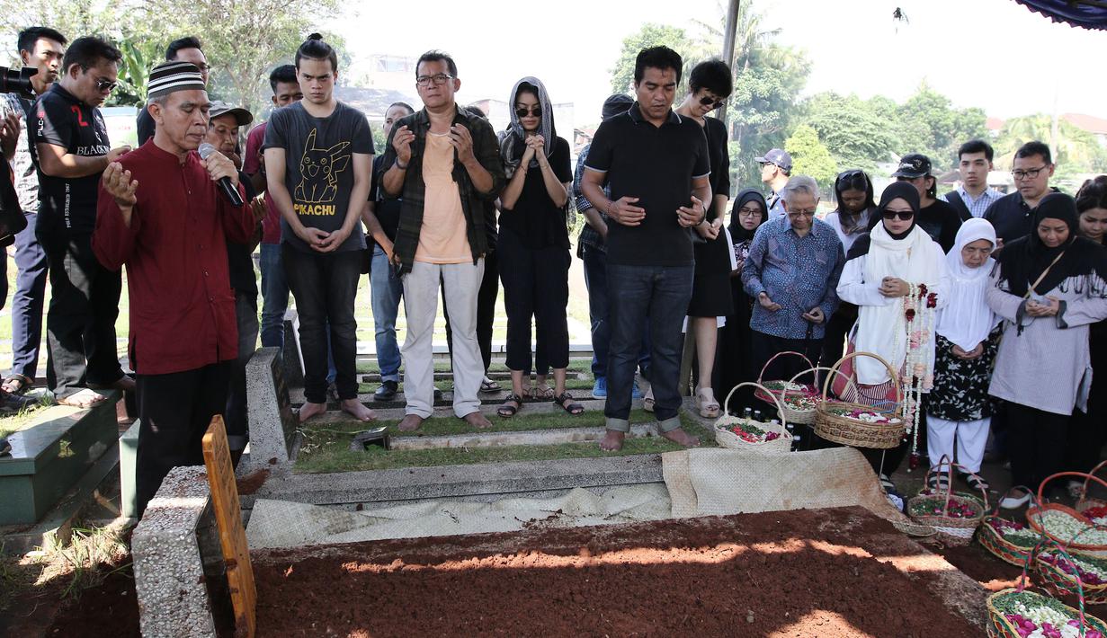Musisi Indra Lesmana bersama keluarga dan kerabat berdoa saat pemakaman ibunya, Nien Lesmana di TPU Tanah Kusir, Jakarta, Rabu (28/6). Ibu dari Indra Lesmana dan Mira Lesmana meninggal dunia pada usai 88 tahun. (Liputan6.com/Herman Zakharia)