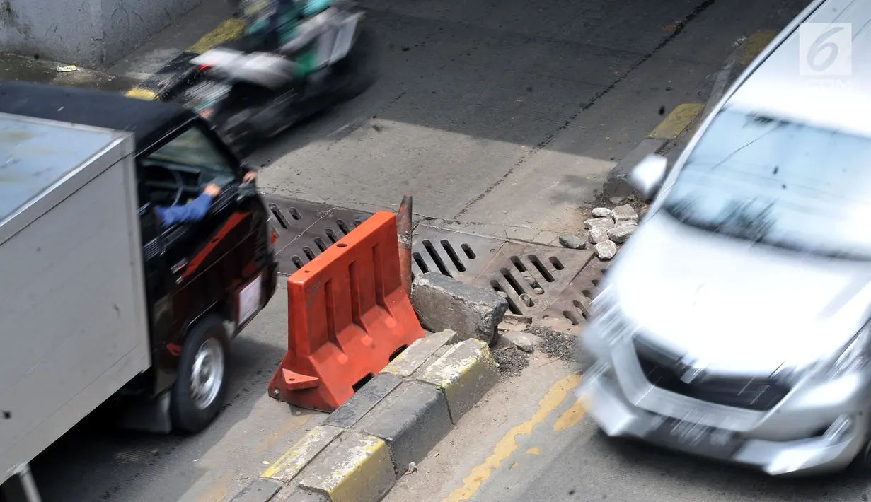Kedaraan melintasi penutup selokan yang ambles di kolong Manggarai, Jakarta, Kamis (14/3). Penutup selokan tersebut kembali ambles meski sudah diperbaiki berkali-kali. (merdeka.com/Iqbal Nugroho)