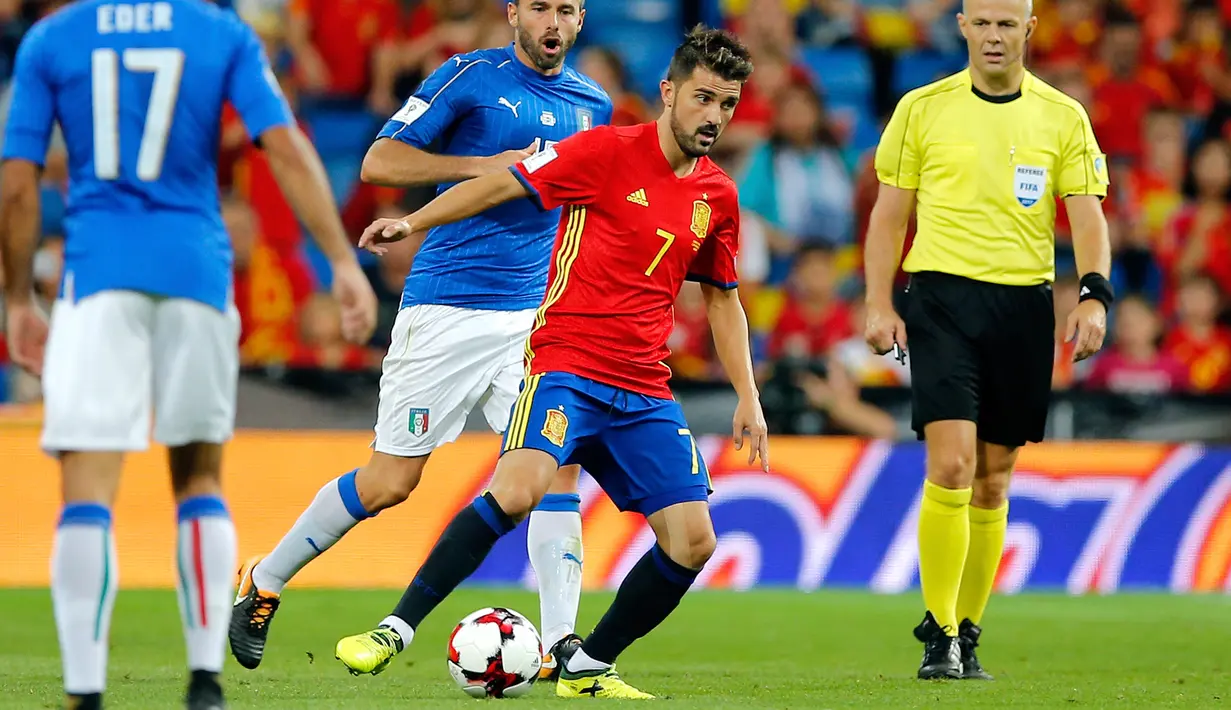 Penyerang Spanyol, David Villa berusaha membawa bola dari kawalan pemain Italia saat bertanding di kualifikasi Piala Dunia 2018 di Stadion Santiago Bernabeu di Madrid, (2/9). Spanyol menang atas Italia 3-0. (AP Photo / Paul White)
