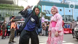 Evelyn Nada Anjani dan DJ nomor satu di Jepang, DJ Shacho berpose menampilkan busananya di atas zebra cross di kawasan Dukuh Atas, Jakarta, Selasa (26/7/2022). Evelyn dan DJ Shacho ikut meramaikan fenomena Citayam Fashion Week dengan tampil mengenakan busana khas negeri Sakura, Jepang. (Liputan6.com/Faizal Fanani)