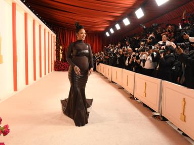 Penyanyi/aktris Barbados Rihanna menghadiri Academy Awards ke-95 atau Oscar 2023 di Teater Dolby di Hollywood, California pada Minggu, 12 Maret 2023, waktu setempat. Pelantun "Where Have You Been" ini berbalut gaun ikat kulit dari Alaïa yang dibuat khusus sembari memamerkan baby bump. (Photo by VALERIE MACON / AFP)