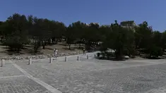 Orang-orang berjalan di bawah Acropolis kuno, di Athena Yunani, Selasa (3/8/2021). Pihak berwenang di Yunani telah menutup Acropolis dan situs kuno lainnya karena gelombang panas yang membakar Mediterania timur terus memburuk. (AP Photo/Michael Varaklas)