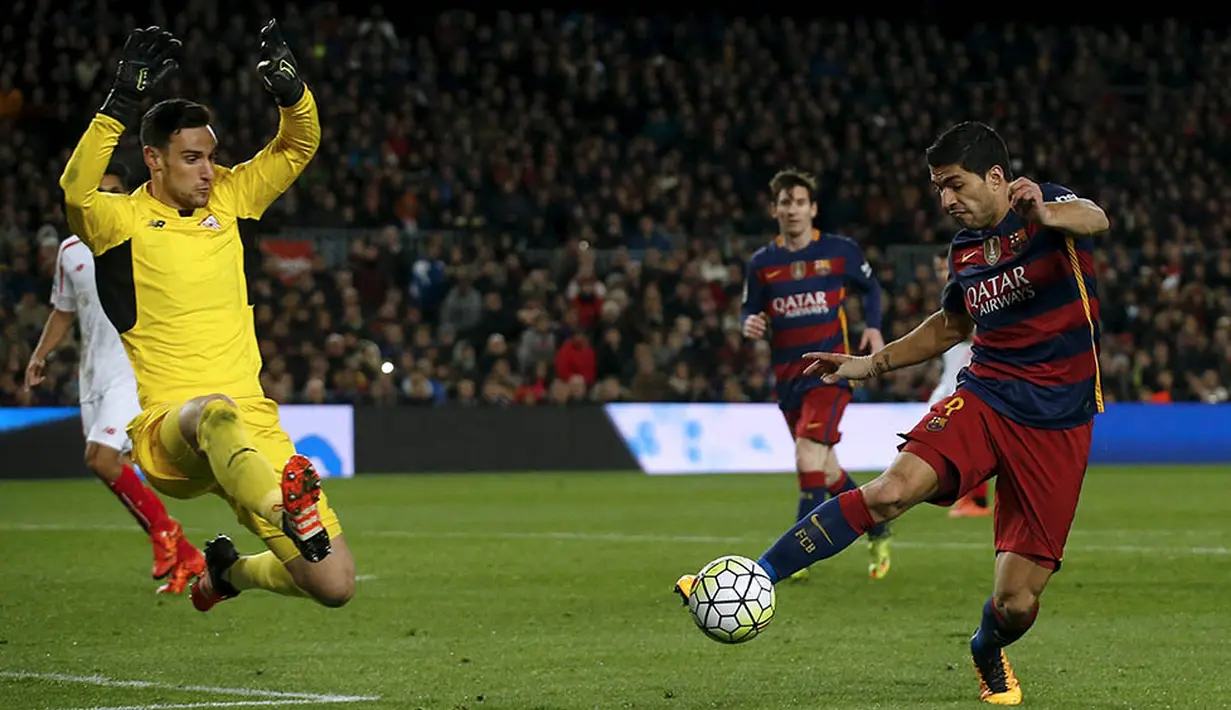 Gerakan striker Barcelona, Luis Suarez, mengecoh kiper Sevilla, Sergio Rico. Pada laga itu Suarez berhasil menyumbang sebuah assist. (Reuters/Albert Gea)