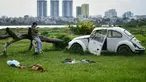 Seorang gadis memeriksa ponselnya sambil duduk di lapangan terbuka di sepanjang tepi sungai Merah di Hanoi (13/0/2020). (AFP/Manan Vatsyayana)