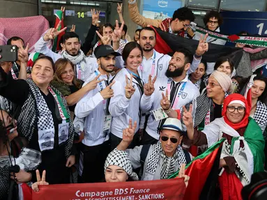 Para atlet Olimpiade Palestina dan anggota delegasi berpose dengan para pendukungnya setibanya di Bandara Charles-de-Gaulle, Roissy-en-France, sebelah utara Paris, pada 25 Juli 2024. (Ahmad GHARABLI/AFP)