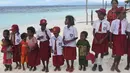 Anak-anak suku Byak Betew memakai seragam sekolah saat menyambut pengunjung di pulau Saukabu, satu dari 1.500 pulau di Raja Ampat 20 Agustus 2017. (AFP Photo/Goh Chai Hin)