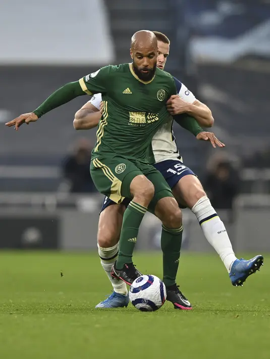 Bek Tottenham Hotspur, Eric Dier berusaha merebut bola darai pemain Sheffield United, David McGoldrick pada pertandingan Liga Inggris di Stadion Tottenham Hotspur di London, Senin (3/5/2021).Tottenham menang telak atas Sheffield United 4-0. (Justin Setterfield/Pool via AP)