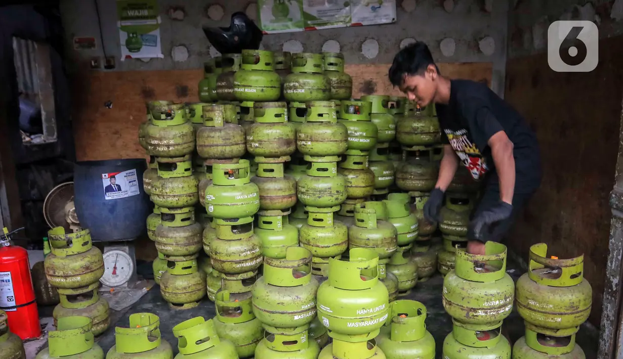 Pekerja menata tabung liquefied petroleum gas (LPG) 3 Kg di sebuah agen di kawasan Jakarta, Rabu (27/12/2023). Pemerintah mendorong penyaluran LPG 3 Kg lebih tepat sasaran dengan menggunakan Kartu Tanda Penduduk (KTP) mulai 1 Januari 2024. (Liputan6.com/Angga Yuniar)