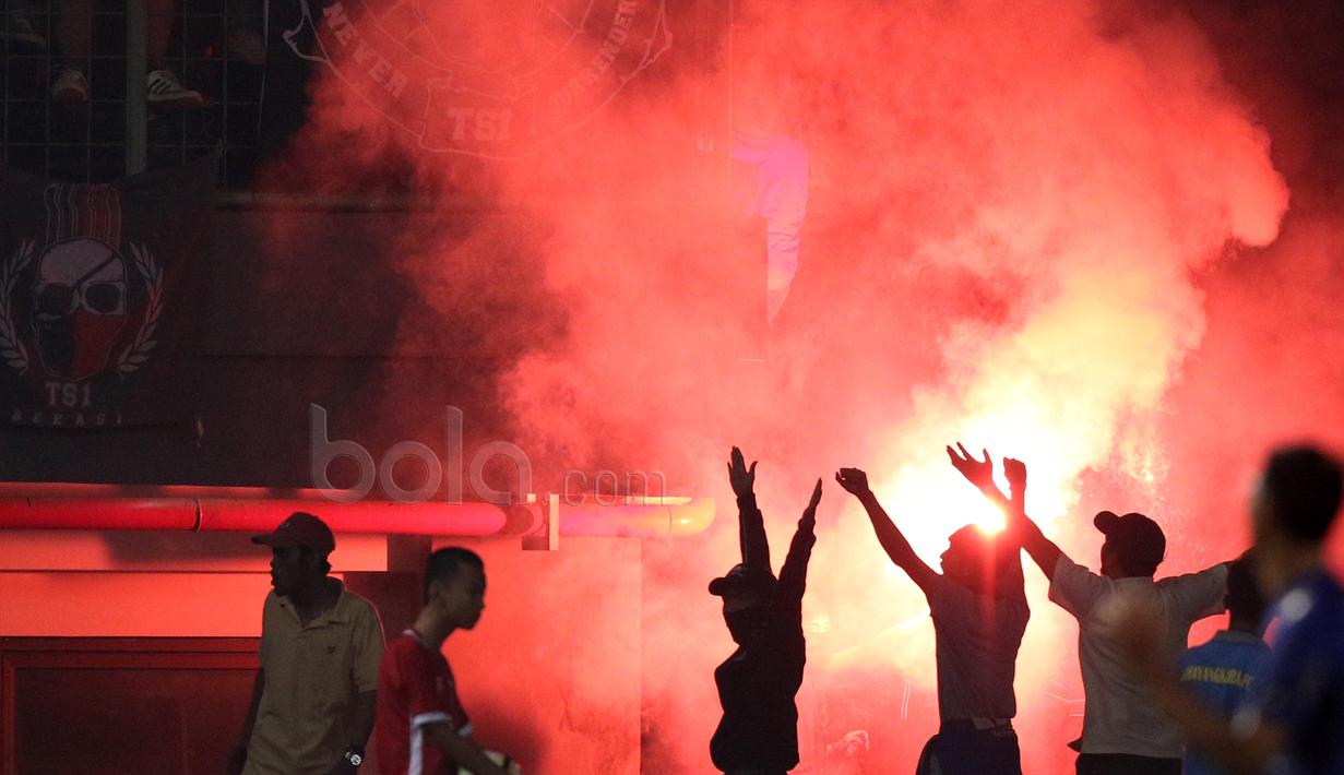 Aksi Bobotoh saat menyalakan flare pada laga Bhayangkara FC melawan Persib Bandung di Stadion Patriot, Bekasi, Minggu (4/6/2017). Persib kalah 0-2. (Bola.com/Nicklas Hanoatubun)