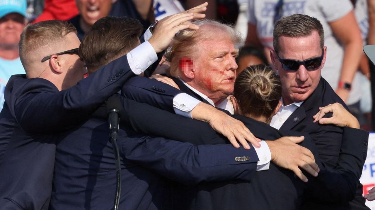 Trump terlihat langsung menunduk sambil memegang telinga kanannya setelah terdengar letusan tembakan pertama.
