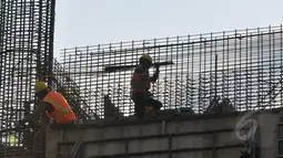Tampak pekerja mengangkat besi menyelesaikan proyek pembangunan gedung, Jakarta, Senin (30/3/2015). Tahun 2015, BPJS Ketenagakerjaan menargetkan mampu mendapatkan 22,3 juta peserta BPJS jumlah ini naik dari tahun 2014. (Liputan6.com/Johan Tallo)