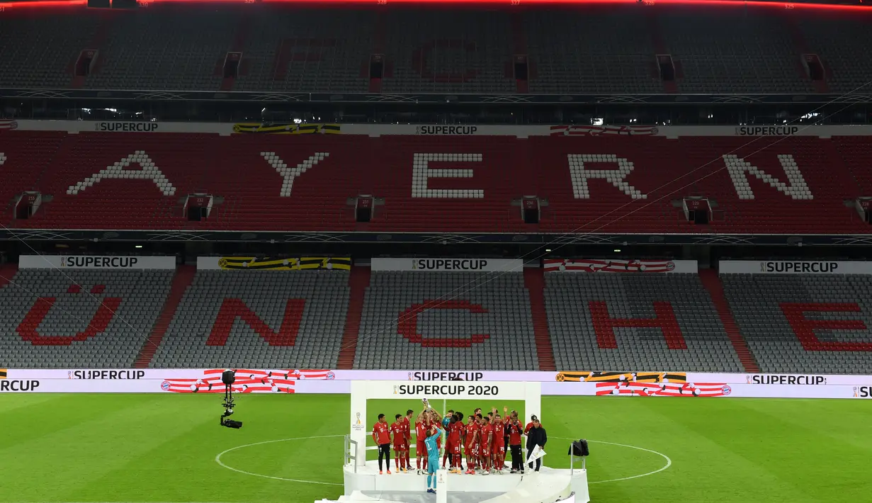 Para pemain merayakan dengan trofi juara Piala Super Jerman usai mengalahkan Borussia Dortmund di Munich, Jerman, 30 September 2020. (Photo by Christof STACHE / various sources / AFP)