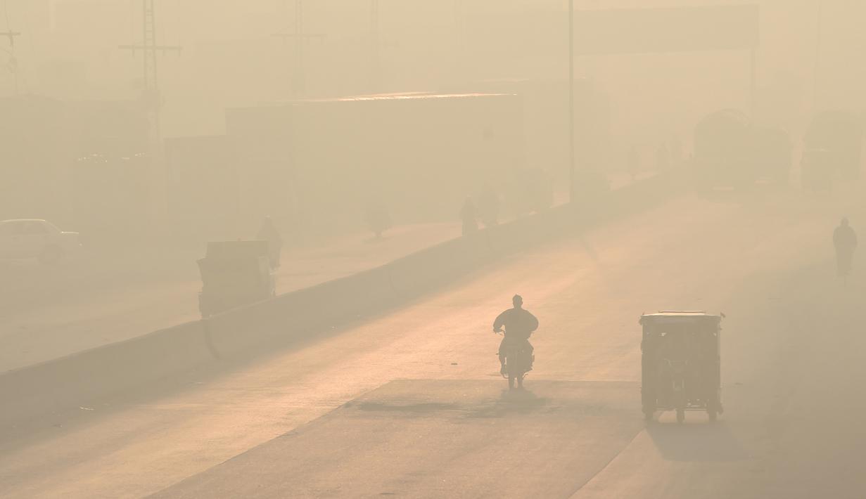 Pengendara melintas di sepanjang jalan di tengah kondisi kabut asap di Lahore, Pakistan (23/11/2021). Kondisi kabut asap yang memburuk membuat Lembaga pendidikan, kantor swasta tutup selama tiga hari seminggu di Lahore. (AFP/Arif Ali)