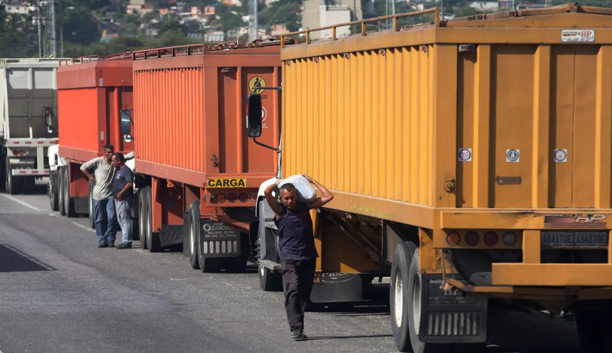 Seorang pria membawa sekarung jagung yang dicuri dari truk di luar pelabuhan di Puerto Cabello, Venezuela, Selasa (23/1). Inflasi yang mencapai 2.600 persen berakibat pada mata uang Venezuela tidak lagi bernilai di masyarakat. (AP Photo/Fernando Llano)