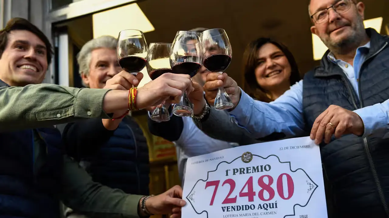 Orang-orang merayakan di luar salah satu toko tempat tiket lotre dijual di Logroño, ibu kota wilayah La Rioja. (Ander Gillenea/AFP)