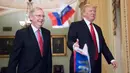 Bendera Rusia dilemparkan ke arah Presiden AS, Donald Trump yang berjalan bersama senator Mitch McConnel di Capitol Hill, Washington DC, Selasa (24/10). Pada saat itu, Trump hendak hadir di acara makan siang rutin dengan senator. (AP/J. Scott Applewhite)