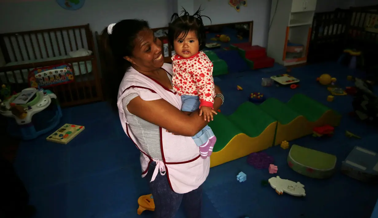 Salah satu narapidana menggendong seorang anak di taman kanak-kanak di penjara wanita Santa Monica, Lima, Peru (31/10). (Reuters/Mariana Bazo)