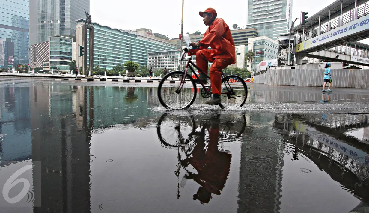 Seorang warga bersepeda di kawasan Car Free Day, Jakarta, Minggu (28/2/2016). Hujan yang mengguyur Ibukota sejak semalam hingga pagi membuat kawasan CFD sepi pengunjung. (Liputan6.com/Immanuel Antonius)