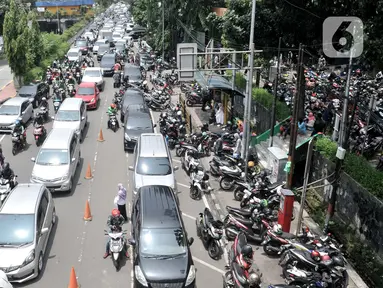 Kendaraan terjebak kemacetan di depan Pasar Pramuka, Jakarta, Senin (16/3/2020). Pasar Pramuka diserbu pembeli yang mencari masker guna mengantisipasi virus Corona Covid-19, membuat sebagian badan jalan dimanfaatkan sebagai parkiran sehingga menyebabkan kemacetan panjang. (merdeka.com/Iqbal Nugroho)