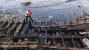 Warga tengah membongkar bangkai kapal di kawasan Kampung Nelayan Cilincing, Jakarta Utara Rabu (8/2). (Fery Pradolo/Liputan6.com)