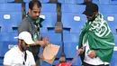 Suporter Arab Saudi mengumpulkan sampah di tribun seusai laga melawan Uruguay pada pertandingan kedua Grup A Piala Dunia 2018 di Rostov Arena, Rabu (20/6). Kalah 0-1, Arab Saudi menjadi tim kedua yang tersingkir setelah Maroko. (AFP/JOE KLAMAR)