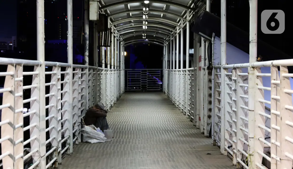 Pemulung beristirahat di Jembatan Penyebrangan Orang (JPO) Jalan Rasuna Said, Jakarta, Selasa (7/4/2020). Pemerintah telah resmi menetapkan Pembatasan Sosial Berskala Besar (PSBB) di wilayah DKI Jakarta dalam rangka percepatan penanganan COVID-19. (Liputan6.com/Helmi Fithriansyah)